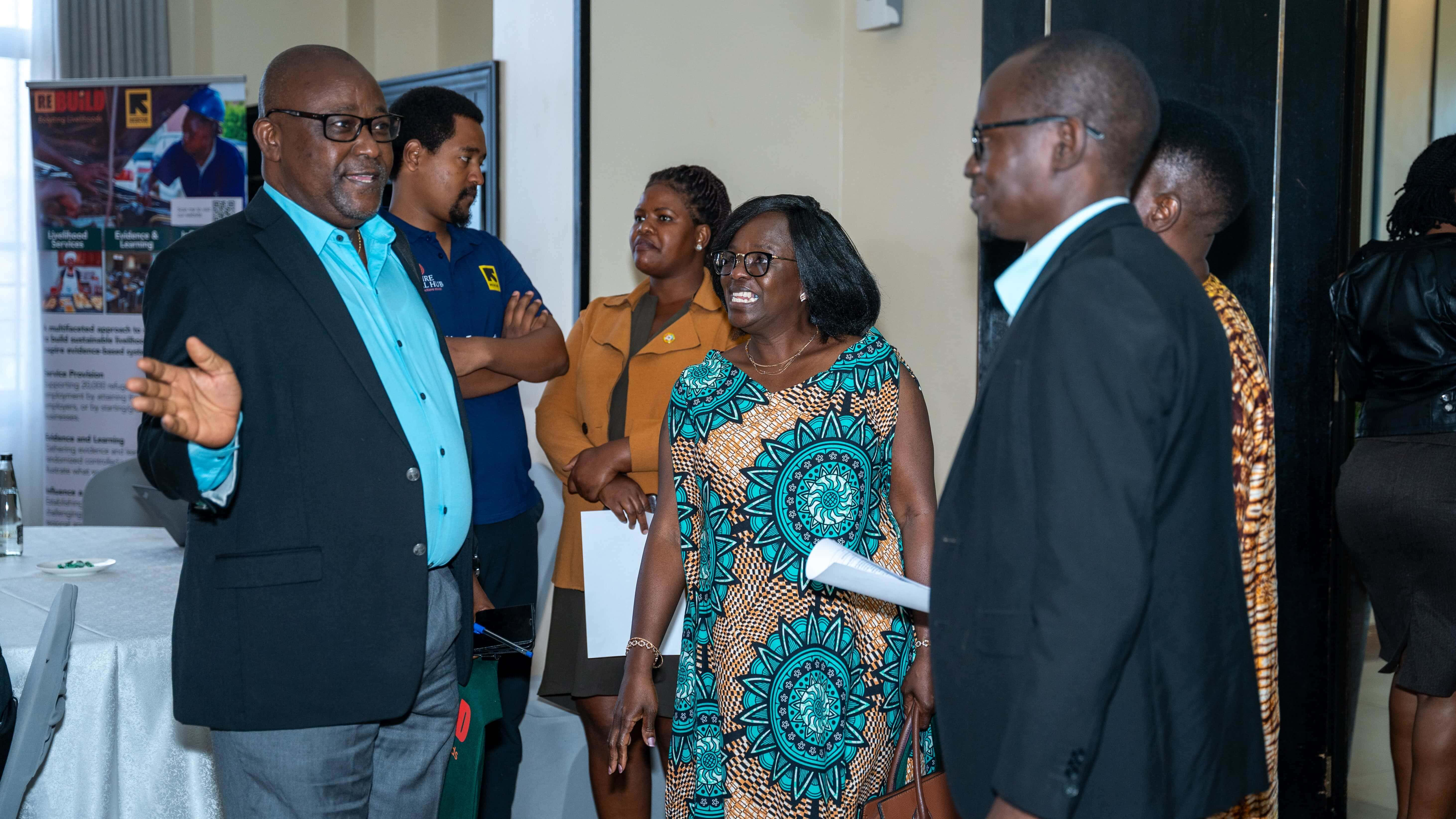 Josiah K Flomo, Head of UrbanKampala Unit at UNHCR interacts with Priscilla Dembetembe,the ReBUiLD Program Director during the decent work summit at Mestil Hotel