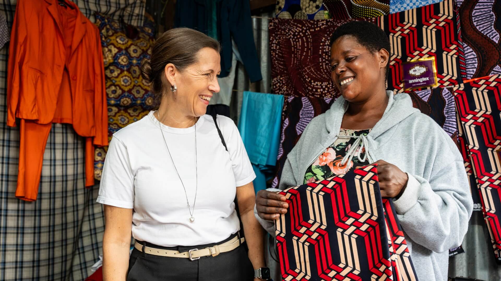 The IKEA Foundation's CEO Jessica Anderen interacts with Josephine Nakabugu at her shop in Kawangware