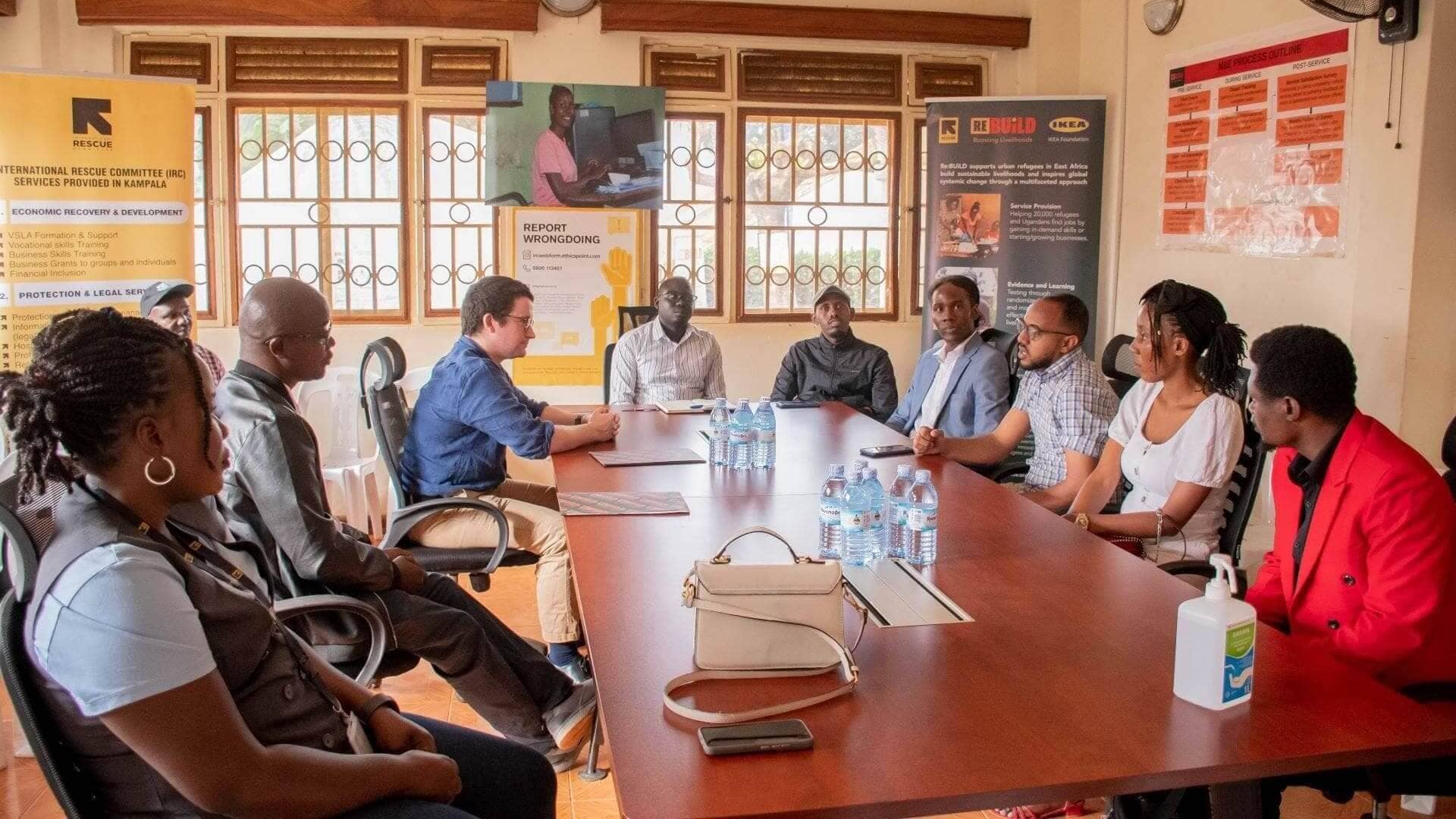 William Carver-Grenside (in blue shirt), Second Secretary Humanitarian - British High Commission, Kampala alongside Elijah Okeyo the IRC Uganda Country Director interact with clients at the IRC Livelihoods Resource Centre in Nsambya