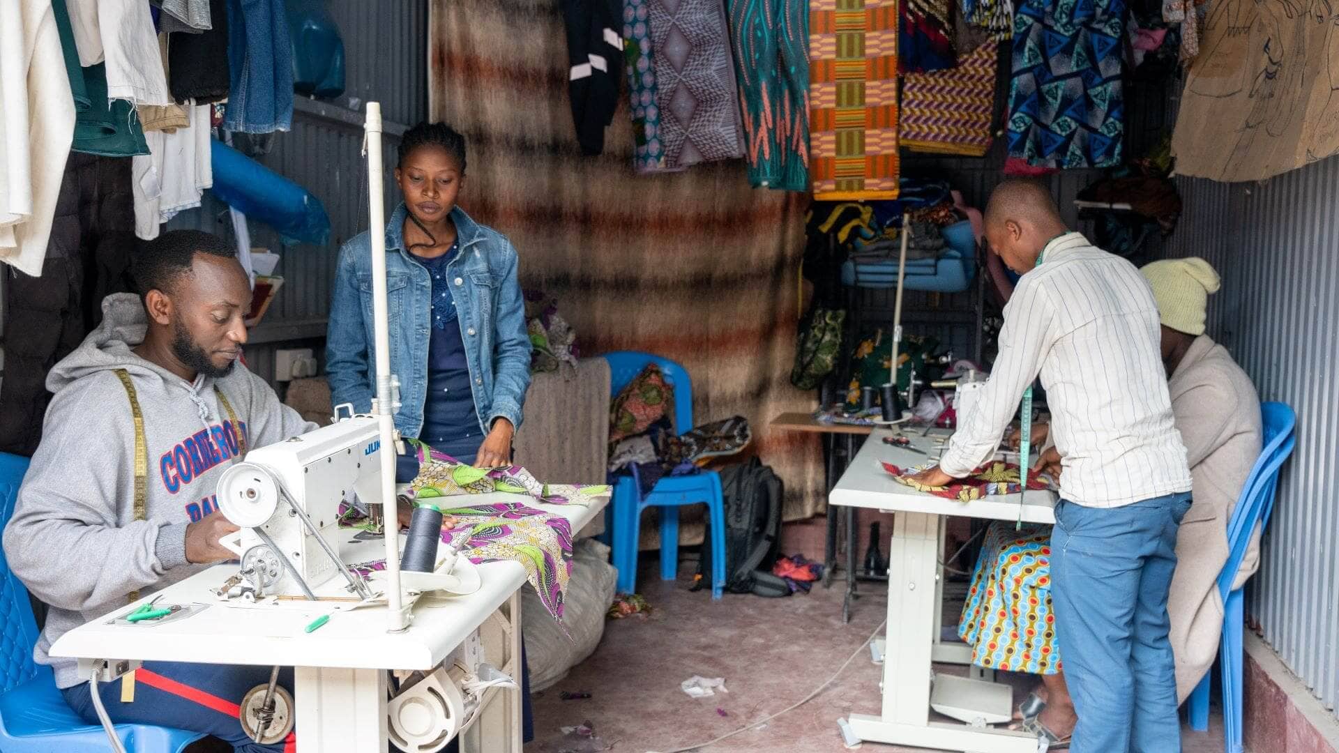 Trainers teaching trainees how to sew at Patrick Gisore's tailoring shop. Patrick focuses on empowering refugee widows and members of the host community with sewing skills, enabling them to start their own businesses, just like he did